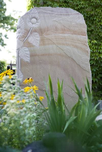 Heller Sandstein-Grabstein mit reliefartig herausgearbeiteter Sonnenblume